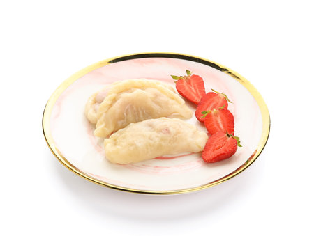 Plate with tasty dumplings and strawberries on white backgroundの写真素材