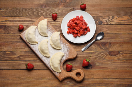 Composition with raw dumplings and strawberry on wooden backgroundの写真素材