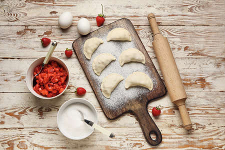 Composition with raw dumplings and ingredients on light wooden backgroundの写真素材
