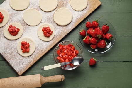 Composition with raw dough for dumplings and strawberry on color wooden backgroundの写真素材