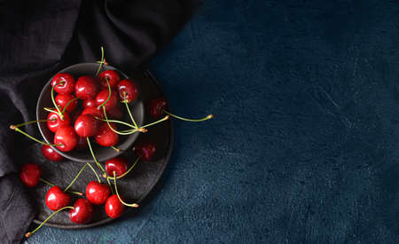 Bowl with sweet cherry on dark backgroundの写真素材