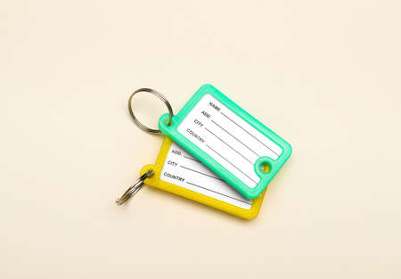 New plastic key tags on beige background