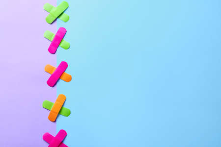 Different adhesive plasters on color background