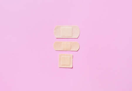Different medical plasters on pink backgroundの写真素材