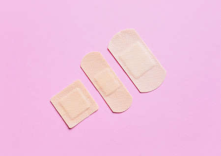 Different medical plasters on pink backgroundの写真素材