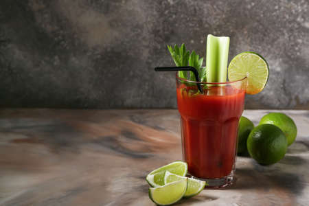Glass of bloody mary cocktail and limes on grunge backgroundの写真素材