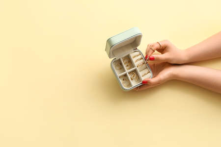 Young woman with beautiful manicure and jewelry box on color background