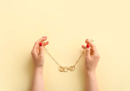 Woman with beautiful manicure holding necklace on color backgroundの写真素材