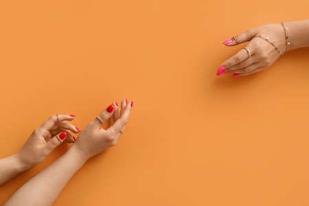 Female hands with beautiful manicure and stylish jewels on color backgroundの写真素材