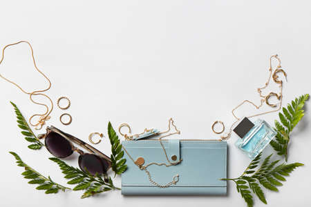 Composition with stylish jewelry and female accessories on light background
