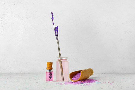 Bottles of lavender essential oil with flowers on light backgroundの写真素材