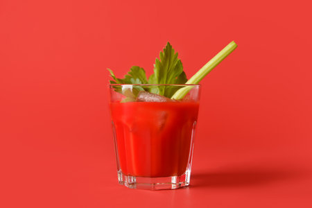 Glass of bloody mary with celery on color backgroundの写真素材