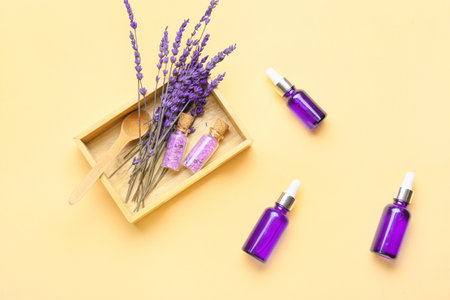 Composition with bottles of lavender essential oil and flowers on color backgroundの写真素材