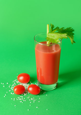 Glass of bloody mary with celery and tomatoes on color backgroundの写真素材
