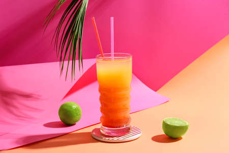 Glass of tasty summer cocktail on color backgroundの写真素材