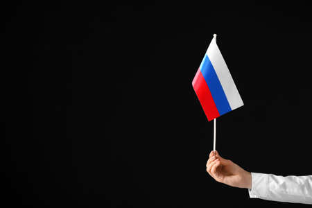 Woman holding flag of Russia on dark backgroundの写真素材