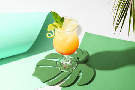 Glass of tasty summer cocktail on color background