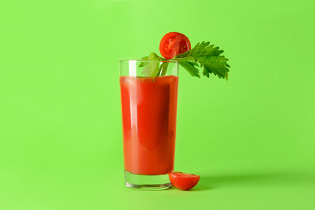 Glass of bloody mary with celery and tomato on color backgroundの写真素材