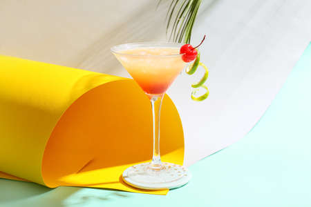Glass of tasty summer cocktail on color background