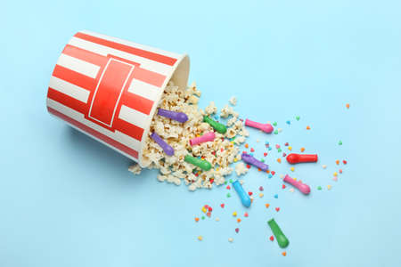 Bucket with popcorn and balloons on blue backgroundの写真素材
