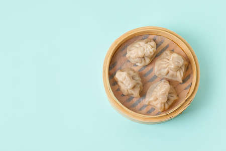 Bamboo steamer with tasty dumplings on color backgroundの写真素材