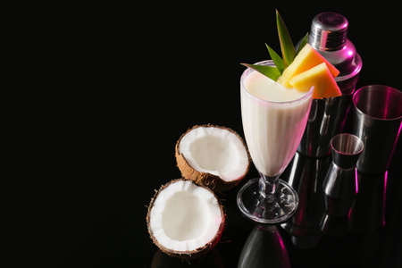 Glass with tasty Pina Colada cocktail on dark background