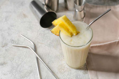 Glass with tasty Pina Colada cocktail on light background