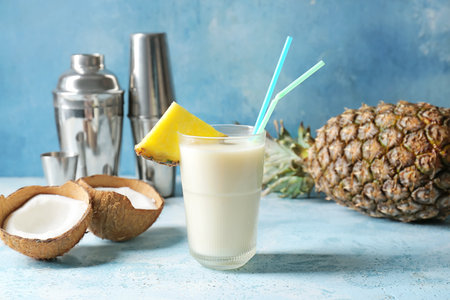 Glass with tasty Pina Colada cocktail on color background