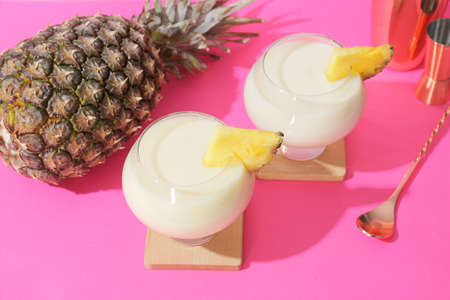 Glasses with tasty Pina Colada cocktail on color background