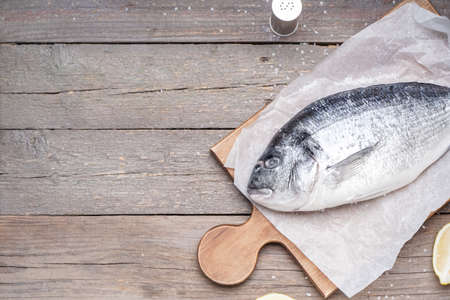 Board with raw dorado fish on wooden backgroundの写真素材