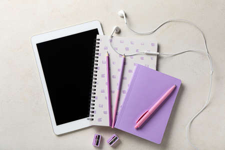 Stationery supplies, tablet computer and earphones on light backgroundの写真素材
