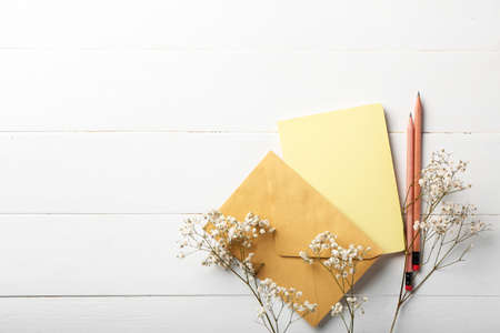 Stationery supplies and gypsophila flowers on white wooden backgroundの写真素材
