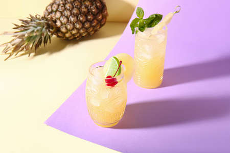 Glasses of delicious mai tai cocktail on color backgroundの写真素材