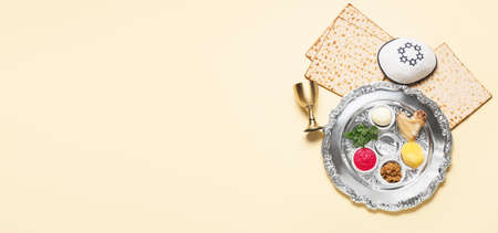 Passover Seder plate with traditional food and kippah on light background with space for textの写真素材