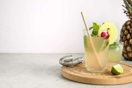 Glass of delicious mai tai cocktail on light background