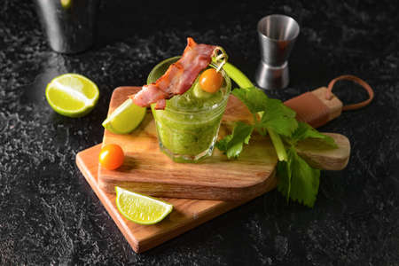 Glass of bloody Mary cocktail garnished with bacon on dark backgroundの写真素材