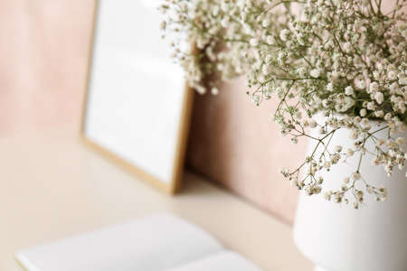 Vase with gypsophila flowers on shelf near pink wall, closeupの写真素材