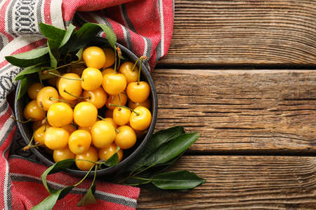 Bowl with tasty sweet cherries on wooden backgroundの写真素材