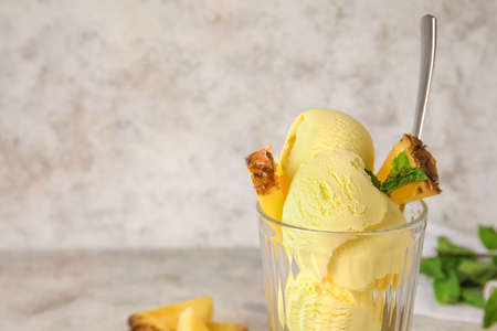 Glass with tasty pineapple ice cream on light background, closeup