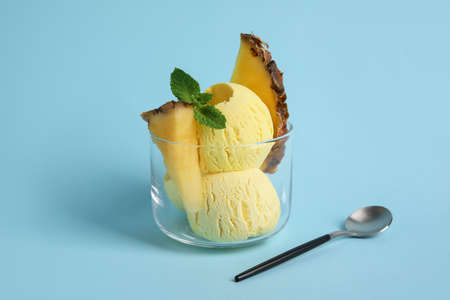 Glass with tasty pineapple ice cream on color backgroundの写真素材