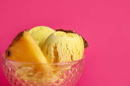 Glass bowl with tasty pineapple ice cream on color background, closeup