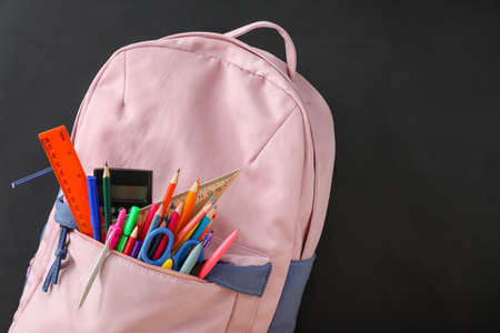 School backpack and stationery near blackboard