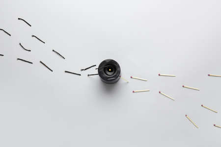 Burning candle and different matches on light background. concept of work burnout