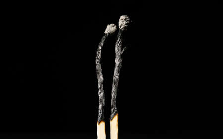 Pair of burnt candles on black background. concept of relationship burnoutの写真素材