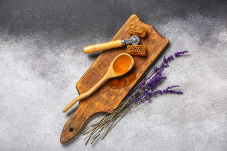 Beekeeping tool and honey on gray background
