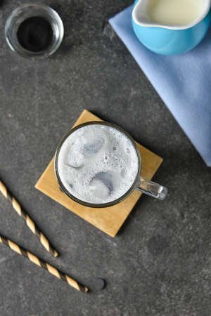 Glass cup of tasty Charcoal Latte on dark background