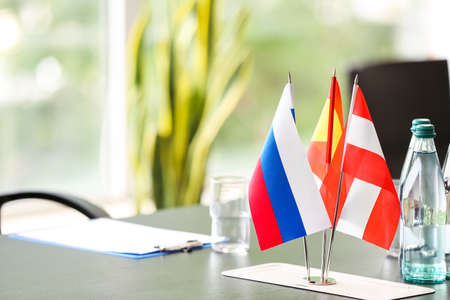 Flags of Austria, Spain and Russia on table in conference roomの写真素材
