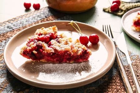 Plate with piece of tasty cherry pie on table, closeup