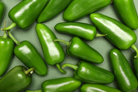 Green jalapeno peppers on color background