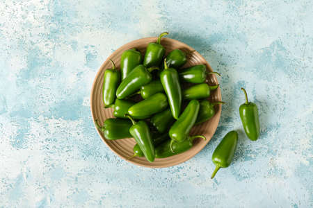 Plate with green jalapeno peppers on color backgroundの写真素材